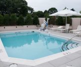 Commercial pool with handrails, steps, and pool spa lift