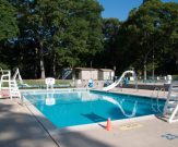 Commercial pool with slide, basketball hoops, and lifeguard stands